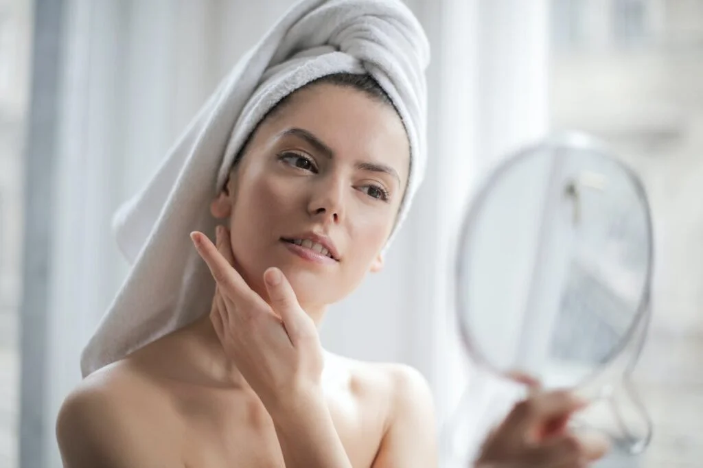 a woman looking at her clear skin