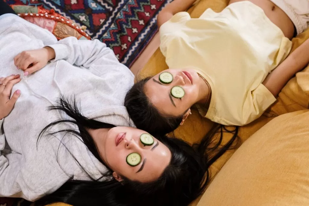 two girls with cucumber on their eyes 