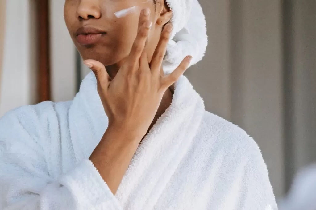 a woman putting moisturizer on 