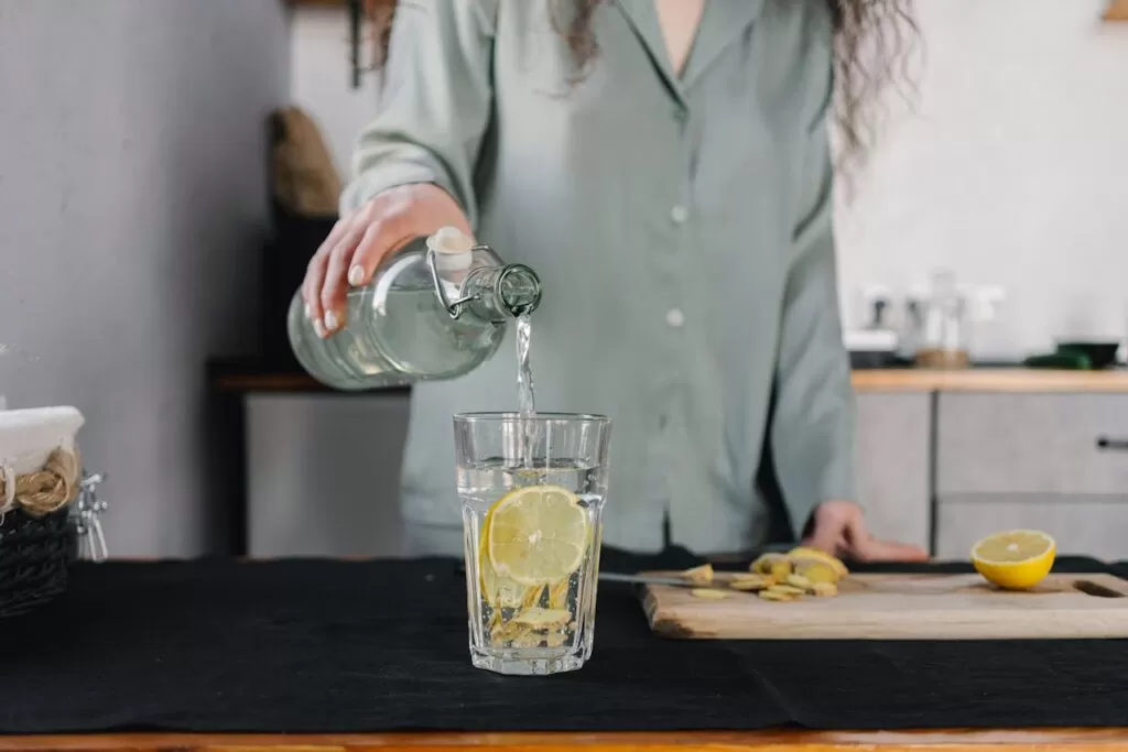 A woman pouring lemon water for a healthy morning self care routine 